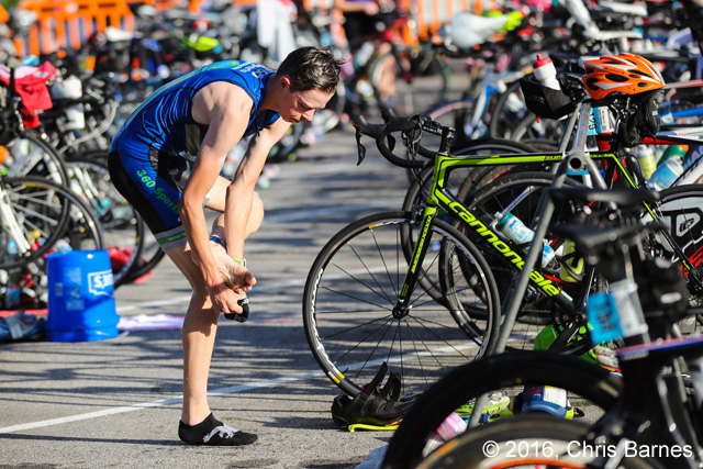 Racer attempts to put on socks with wet feet at the 2016 Tulsa Triathlon